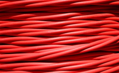 Yüksek voltajlı elektriği santralden santrale taşımak için kalın kırmızı elektrik kablosu yakın plan.