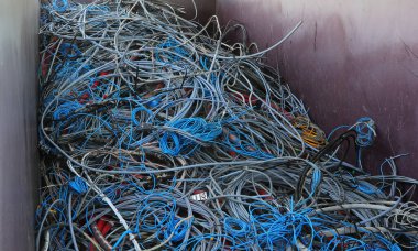 İçinde eski bakır ve PVC elektrik kabloları olan bir konteynırın içinde geri dönüşüm için