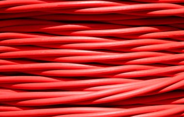 Bir elektrik santralinden yüksek voltaj iletimi için kullanılan kalın kırmızı elektrik kablosunun arka planı