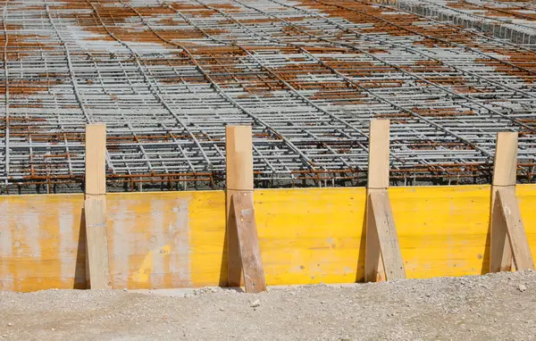 İnşaat tesislerinin inşası için işçilerin olmadığı bir inşaat sahasına takviye beton dökülmesi