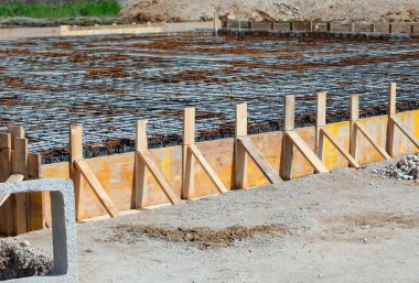 formwork made with yellow wooden planks during laying cement to make the foundation of the building on the construction site without workers clipart