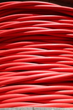 Büyük kırmızı makaralı yüksek voltajlı elektrik kablosu elektrik santralinden elektrik taşımak için kullanılır.