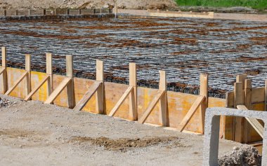 İnşaat alanındaki inşaatın inşaatını işçilerden arınmış hale getirmek için beton döşeme sırasında kalaslarla yapılan formasyon.