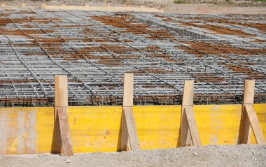 building formwork made with planks during laying cement to make foundation of the building on the construction site without workers clipart