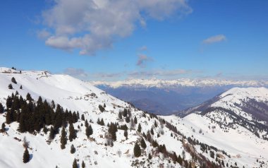 Kuzey İtalya 'daki Alpler' in nefes kesici doğal manzarası. Karla kaplı dağ zirveleri ve kışın mavi gökyüzü.