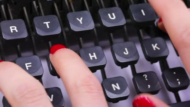 オフィスのヴィンテージタイプライターのキーボードにキーボードを入力する若い女性の赤いネイルポーランドの指 ストック動画