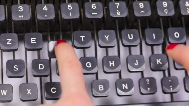 オフィスのヴィンテージタイプライターのキーを入力する秘書の赤い爪の長い指 ロイヤリティフリーストック映像