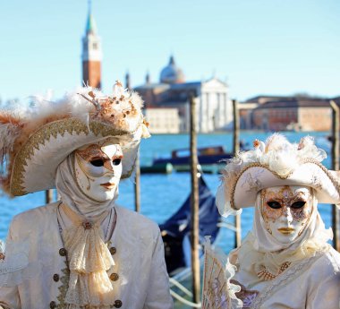 Venedik, VE, İtalya - 13 Şubat 2024: Karnaval sırasında maske takan asil erkek ve kadın ve arka planda Adriyatik Denizi