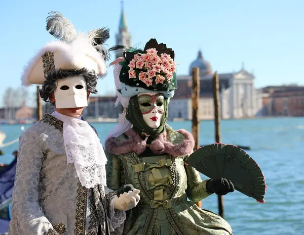 stock image Venice, VE, Italy - February 13, 2024: noble man and woman dressed in masks during the carnival and the sea