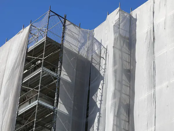 Detailed of residential building scaffolding during maintenance and installation of insulating panels to safeguard the environment and energy saving