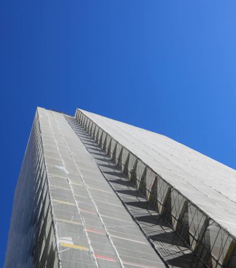 Enerji tasarrufu için bakım ve izolasyon paneli kurulumu için yapı iskelesi ile kaplı.