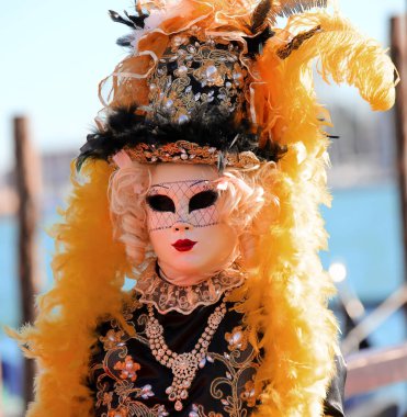 Venedik, VE, İtalya - 13 Şubat 2024: Venedik Karnavalı sırasında yüzünde kırmızı eldiven ve maske ve sarı peruk