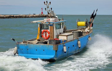 Balığa gitmek için denizin dalgalarına yelken açan hızlı balıkçı teknesi