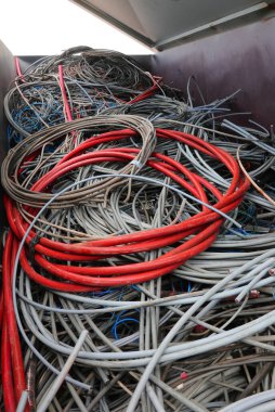 Çok yüksek voltaj için kırmızı elektrik kablosu ve çevreyi kirletmemek için geri dönüşümlü madde çöplüğünde kullanılan birçok elektrik kablosu.