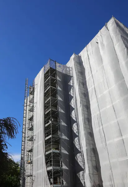 stock image building with construction scaffolding for the installation of insulating panels to reduce consumption and save money