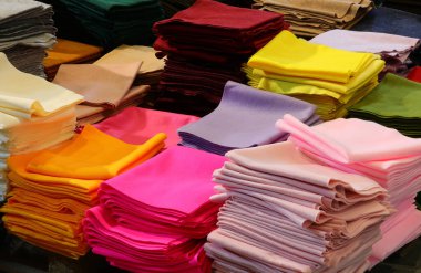 Toptan tuhafiye mağazasında indirimde olan giysi ve hobi eşyaları yapmak için çeşitli renkli kumaş parçaları.