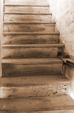 Eski ahşap merdivenler sepia antika bir efektle yukarı çıkıyor.