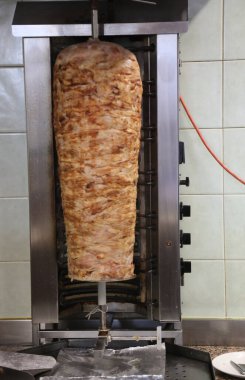 Etli büyük kebap şişi, kendi kendine döner ve yeme alanında bir hareket etkisi yaratır.