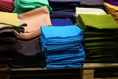 Toptan satış mağazasında giysi ve hobi eşyaları yapmak için çok çeşitli renkli kumaş parçaları.