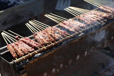 meat skewers called ARROSTICINI cooked on burning embers typical of the cuisine of Southern Italy in the Abbruzzo and Molise regions clipart