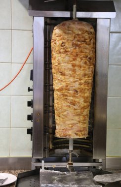 Etli büyük kebap şişi yeme alanında bir hareket etkisiyle kendi kendine dönüyor.