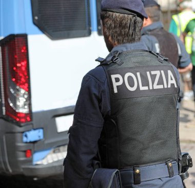 Vicenza, VI, İtalya - 10 Mayıs 2024: İtalyan polis memuru büyük POLİZIA metniyle İtalyanca ve isyan kontrol minibüsünde POLICE anlamına geliyor