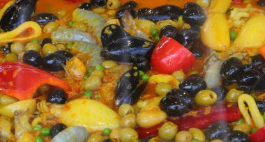 Valensiyalı balık, pilav, kırmızı biber, pirinç, bezelye, midye, yumuşakça ve kırmızı domateslerin malzemelerinin ayrıntıları.