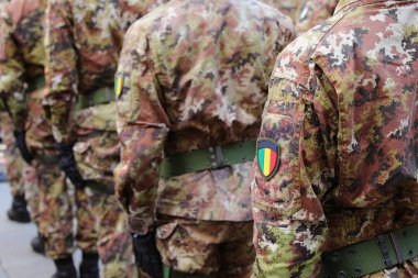 Birçok ordu askeri geçit töreninde yürüyor. Kamuflaj üniformaları ve üç renkli ulusal bayrak giyiyorlar.