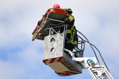 Kurtarma sırasında iki itfaiyeci havada asılı sedye ile vinçte.