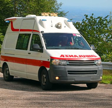 AMBULANZA sözcüğünün tersten okunduğu beyaz bir acil durum minibüsü. Böylece İtalya 'daki dikiz aynasından net bir şekilde okunabiliyor.