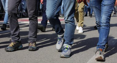 Şehrin yolundaki bir protesto sırasında birçok insanın bacakları yürür.