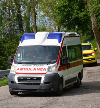 AMBULANZA mesajlı beyaz acil durum minibüsü. İtalyan dilinde AMBULANZA anlamına geliyor. Acil bir çağrı sırasında yanıp sönen ışıklar ve siren.