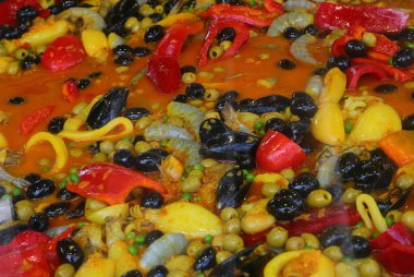 Valensiyalı balıklı paella, pirinç biberli, yeşil bezelyeli, midyeli yumuşakça ve kırmızı domatesli.