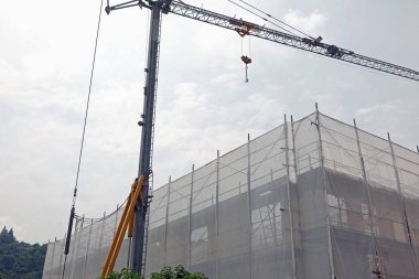 İnşaat sahasında inşaat iskelesi ve vinç kaldırma termal yalıtım panelleri var.