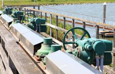 Big motorized sluice gates to regulate water flow in marshy areas and operate pumping stations clipart