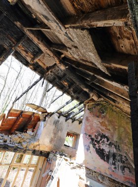 Her şeyi yakan yangından sonra çatısı çökmüş bir ev.