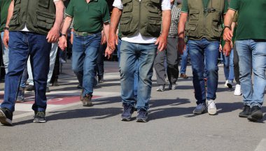 Kalabalık bir protestocu kalabalığı gibi sokaklarda yürürken bir sürü erkek bacağı.