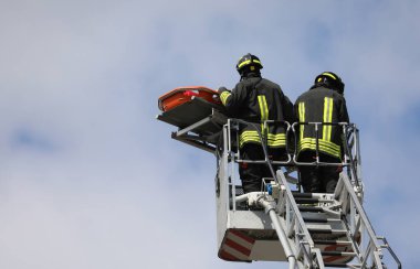 Yaralı kişiyi sedyeyle kurtarırken itfaiye aracının hava sepetinde iki itfaiyeci vardı.