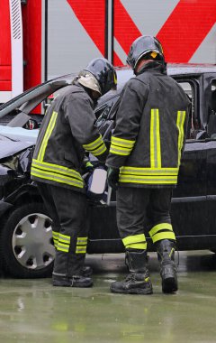 İtfaiyeciler kazadan sonra otoyolda çarpan arabanın kapısını açmak için güçlü çene ve hidrolik ram kullanıyorlar.