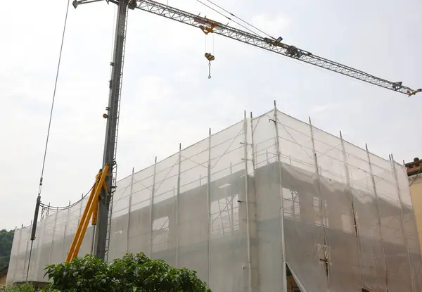 stock image Construction site during the building of a structure with scaffolding and a crane to lift heavy loads without people