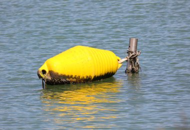 Su altı kayalıkları ve resifleri hakkında uyarmak için yüzen büyük sarı şamandıra.