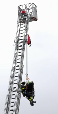 Cesur itfaiyeci, uzun itfaiye merdiveninde yaralı birini kurtardı.