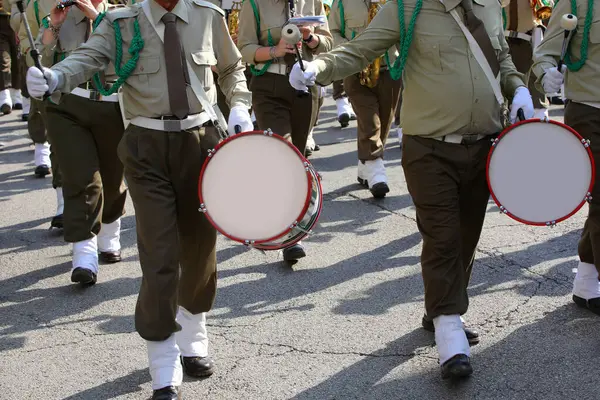 Stock image marching band with many drummers and other musicians playing along the city streets