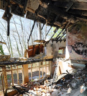 Her şeyi yakan yangından sonra çatısı çökmüş bir ev.