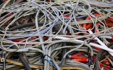 Bir zamanlar elektrik iletimi için kullanılan ve şimdi de geri dönüşüm için kullanılacak çok sayıda elektrik kablosunun arkaplanı