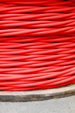 Elektrik santralinden ana santrallere elektrik aktarımı için yüksek voltajlı kırmızı kablo makarası..