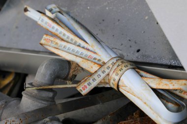 Çevreyi korumak için geri dönüşüm merkezinde kırık bant mezurası ve bükülmüş çarşaflı hurda metal.