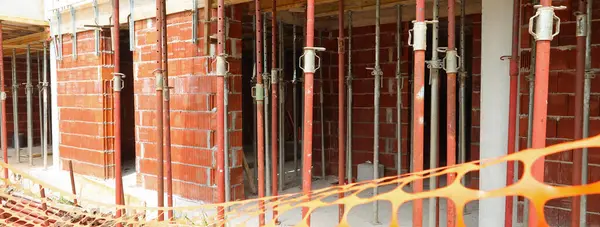 stock image construction site barrier fence during building construction of a building without people with props for supporting the slabs