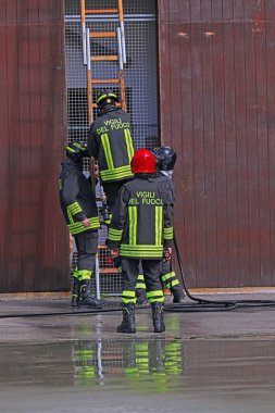 Vicenza, VI, İtalya - 23 Mayıs 2024: Şef, itfaiye ekibinin binaya tırmanması için merdiveni kurmalarını emrediyor.