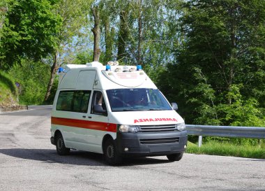 Treviso, TV, Italy - May 25, 2024: White ambulance van with large reversed red text in Italian and blue sirens clipart